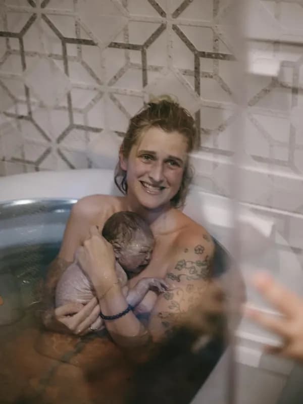 Mama mit Neugeborenem nach der Wassergeburt — selbstbestimmte Geburt